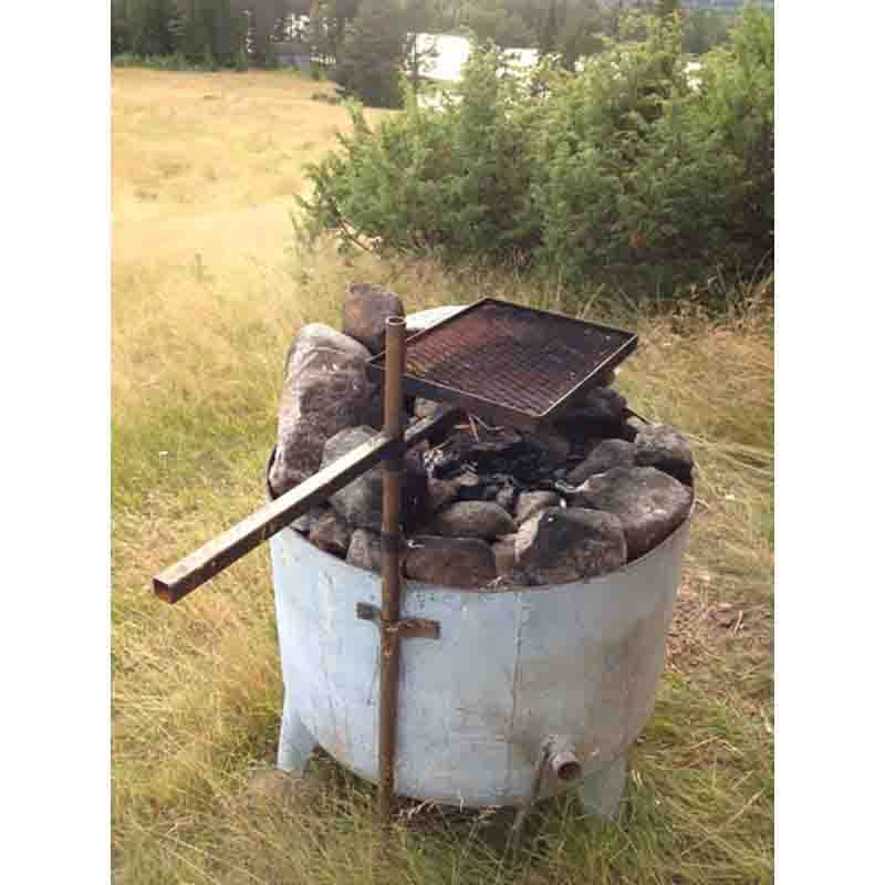 En grillplats är gjord av ytterdelen på en stor gammal vattekokare med ben av stål. Ett markrör är fäst på utsidan och ett grillgaller 30x40 från  Eldmark är monterat på röret. Eldstaden finns på holme i Vindelälven.